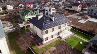 Şehir merkezindeki fotovoltaik güneş panelleri olan modern konut binasının video görüntüleri. Çatıda güneş paneli olan yeni bir ev. Alternatif enerji ve güç sürdürülebilir kaynaklar kavramı.