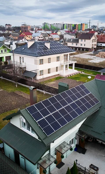 Modern houses with photovoltaic solar panel modules on rooftop. Houses, residential buildings and homes with solar electric system in new neighborhood. Renewable energy concept.
