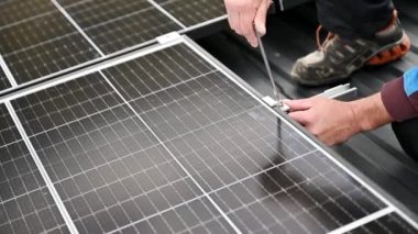Evin çatısına fotovoltaik güneş panelleri monte eden teknisyen. Büyülü anahtarın yardımıyla güneş modülü sistemi kuran mühendisi kapatın. Alternatif, yenilenebilir enerji kavramı.