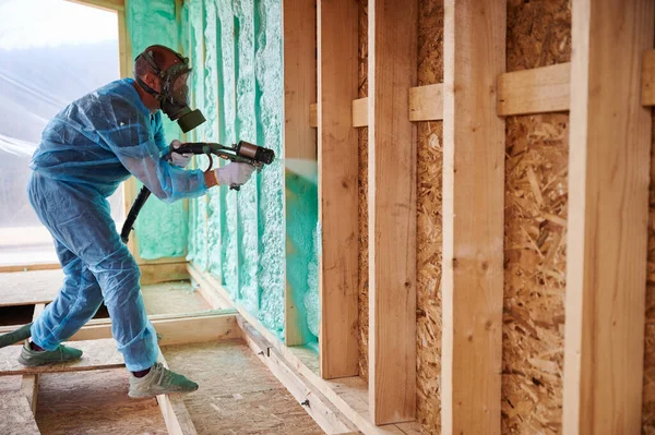 Male Builder Insulating Wooden Frame House Man Worker Spraying Polyurethane — Foto Stock