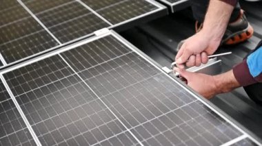 Evin çatısına fotovoltaik güneş panelleri monte eden teknisyen. Büyülü anahtarın yardımıyla güneş modülü sistemi kuran mühendisi kapatın. Alternatif, yenilenebilir enerji kavramı.