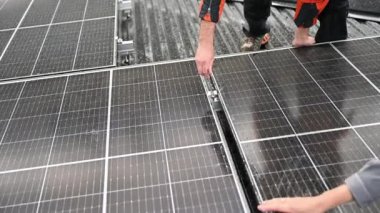 Erkek teknisyen yağmur altında evin çatısına fotovoltaik güneş panelleri monte ediyor. Büyülü anahtarın yardımıyla güneş modülü sistemi kuran mühendisi kapatın. Alternatif, yenilenebilir enerji kavramı.