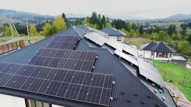 屋根の上に太陽光発電パネルシステムと山の中で新しい近代的な家のコテージの空中ビュー 再生可能エネルギー 住宅自治の概念 — ストック動画