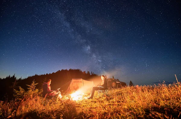 밤하늘 속에서 야영하며 기사보기 여행하는 모닥불에서 휴식을 취하는 관광용 텐트에서 — 스톡 사진