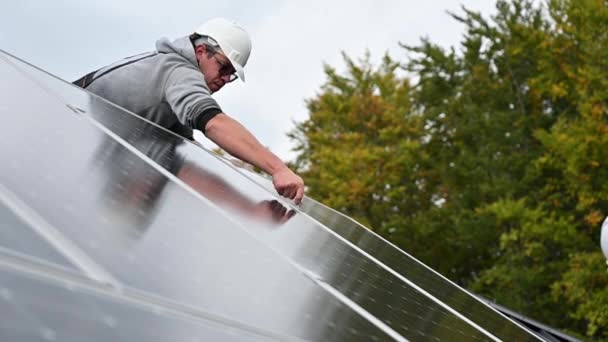 人工技术人员在房顶上安装光电太阳能电池板 头盔工程师用六角钥匙安装太阳能模块系统 可再生能源的替代概念 — 图库视频影像