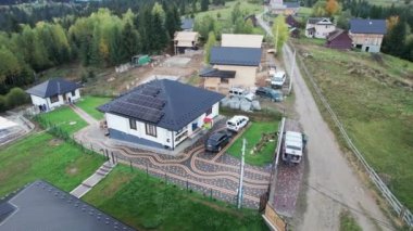 Dağlardaki güneş fotovoltaik panel sistemi çatıda olan yeni modern ev manzarası. Alternatif, yenilenebilir enerji ve ev özerkliği kavramı.