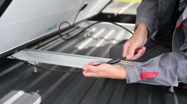 Fotovoltaik güneş paneli kablolarını bağlayan profesyonel bir uzman. Evin tepesine pv güneş pili kurulumu. Bir çatıdaki güneş paneli kablolarını koruyan işçilere yaklaş..