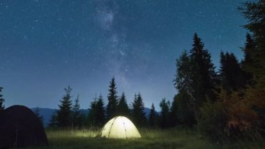 Parlak akşam güneşinin panoramik manzarası ve dağların üzerinde dramatik bulutlu gökyüzü. Renkli akşam gökyüzü altında, bulutlu ve batan güneşli dağ tepelerinin muhteşem manzarası. Doğanın güzelliği konsepti.