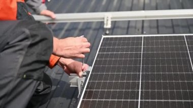 Evin çatısına fotovoltaik güneş panelleri monte eden teknisyen. Büyülü anahtarın yardımıyla güneş modülü sistemi kuran mühendisi kapatın. Alternatif, yenilenebilir enerji kavramı.
