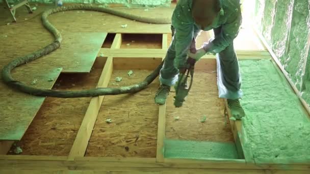 男性建筑工人为木制框架房屋隔热 男工在未来的小木屋内喷涂聚氨酯泡沫 使用多元组件枪 建筑和绝缘概念 — 图库视频影像