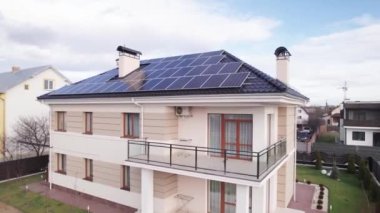 Video footage of modern house with solar panel modules for generating electricity through photovoltaic effect. New home with ecological renewable energy source on roof. Solar power system concept.