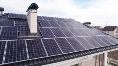 Video footage of photovoltaic solar panels on roof of residential building. House with solar panel system outdoors. Concept of alternative energy and power sustainable resources.