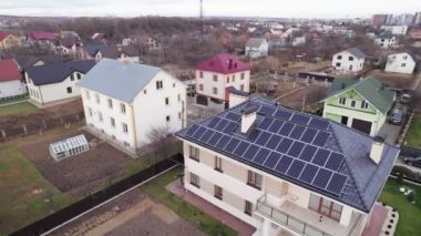 Aerial drone video of residential district with houses, buildings, streets and homes with photovoltaic solar panels. Modern houses with renewable sources of energy in suburban neighborhood.