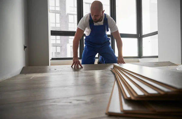 Mann Arbeitskleidung Verlegt Laminatfußboden Wohnzimmer Mit Großem Fenster Männlicher Bauarbeiter — Stockfoto