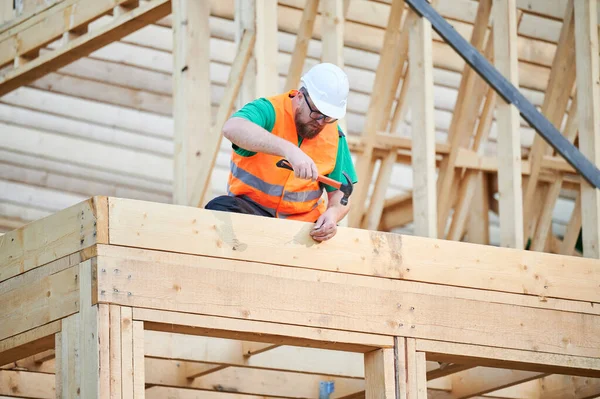 Stolarz Buduje Dwupiętrowy Drewniany Dom Szkieletowy Mężczyzna Noszący Okulary Wbijający — Zdjęcie stockowe