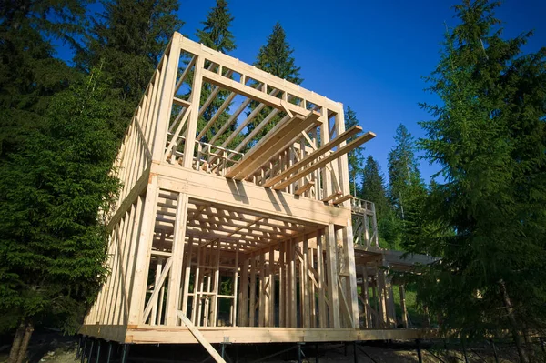 stock image Drones vantage point offers view of two-storey wooden-framed domicile in process of construction near forest. Idea of contemporary ecological construction and modern architectural design.