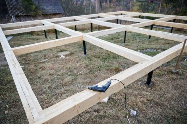 Gelecekteki çerçeve için ahşap yığının üzerine matkap döşeme. Constuction site ve çalışma aracı konsepti.