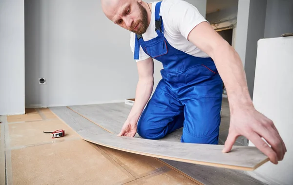 Männliche Bauarbeiter Legen Laminatdielen Auf Den Fußboden Wohnzimmer Mann Arbeitskleidung — Stockfoto