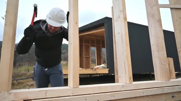 Arbeiter Bauen Holzrahmenhaus Auf Pfahlfundament Schreiner Hämmert Mit Hammer Nagel — Stockvideo