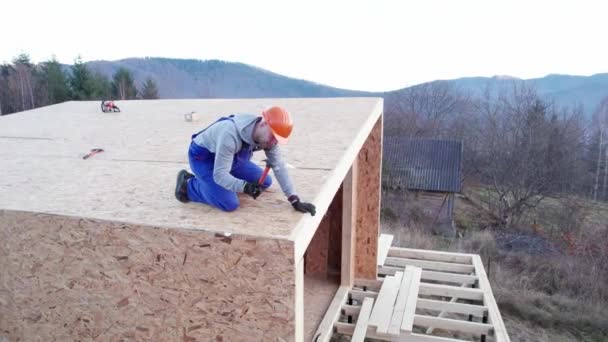 Carpenter Hammering Nail Osb Panel Roof Top Future Cottage Man — Stockvideo