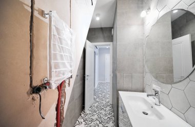 Restorasyondan önce ve sonra elektrikli havlu kurutma makinesi olan bir daire. Lavabosu ve aynası olan eski ve yenilenmiş banyo..