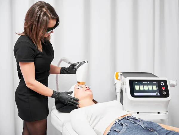 Kobieta Kosmetyczka Pomocą Lasera Diodowego Podczas Wykonywania Zabiegu Pielęgnacji Skóry — Zdjęcie stockowe