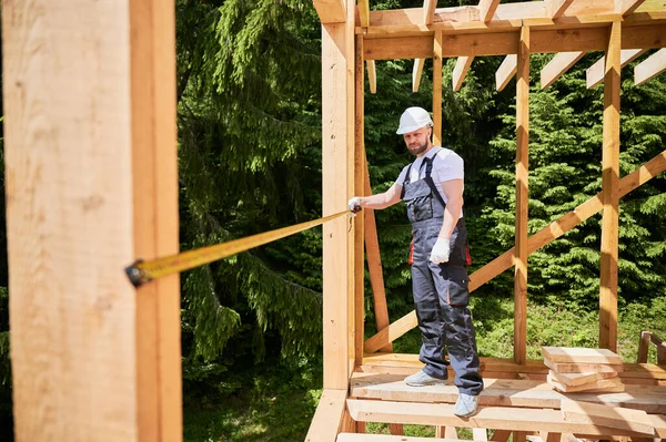 Tischler Beim Bau Eines Holzskelettgebäudes Mann Misst Entfernungen Mit Maßband — Stockfoto