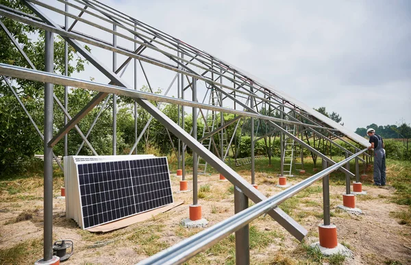 工人们白天在田里的金属梁上安装太阳能电池板 可再生能源和生态能源 作为光伏面板的模块光伏采集 阵列作为光伏面板的一个系统 — 图库照片