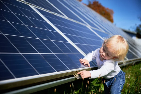Little boy wondering what solar panel is. Curious child trying to understand how does solar battery work. Modern resources of electricity for future generations