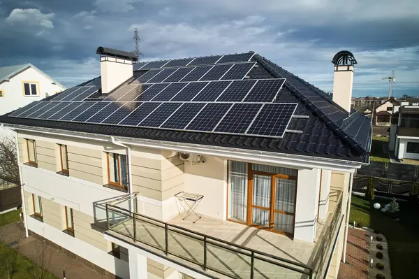 Fotovoltaik etkiyle elektrik üretmek için güneş paneli sistemi olan bir ev. Çatıda güneş modülleri olan iki katlı bir evin havadan görüntüsü. Ekolojik yenilenebilir enerji kaynakları kavramı.