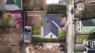 Yeni bölgede çatıda güneş paneli olan bir konut evinin insansız hava aracı videosu. Fotovoltaik etkiyle elektrik üretmek için güneş modülleriyle inşa ediliyor. Alternatif enerji kavramı.