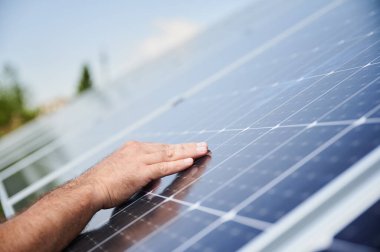 Mühendisler yeni güneş paneline el attı. Modern hayatta yenilenebilir enerji. PV bataryasında erkek eli görüntüsünü kapat.