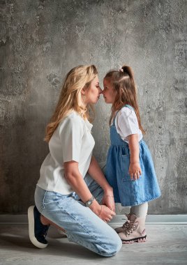 Anne evde duvara yaslanmış sevimli bir çocuğun yan görüntüsü. Aile ve annelik kavramı.