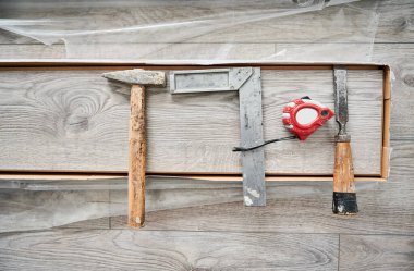 Metal inşaat cetveli, çekiç ve tahta kaplamalı mezura. Döşeme döşeme döşemesi, inşaat ve yenileme için onarım araçları ve araçlar.