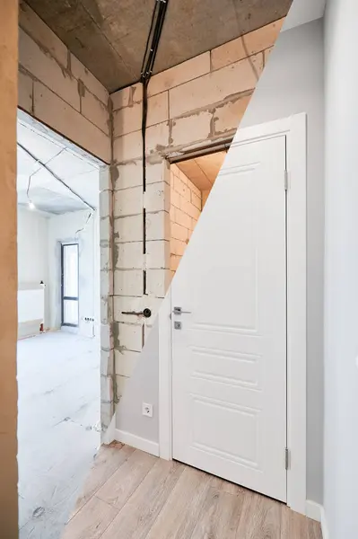Old apartment with brick walls and new renovated flat doors, room and elegant interior design. Comparison of apartment before and after restoration. Home renovation concept.