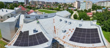 Çatıda fotovoltaik etkiyle elektrik üretmek için güneş panelleri olan bir ev. Çatıda güneş enerjisi sistemi olan bir ev. Alternatif enerji kavramı, özerklik, güç sürdürülebilir kaynaklar.