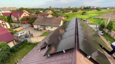 Çatıda fotovoltaik etkiyle elektrik üretmek için güneş panelleri olan bir ev. Çatıda güneş enerjisi sistemi olan bir ev. Alternatif enerji kavramı, özerklik, güç sürdürülebilir kaynaklar.