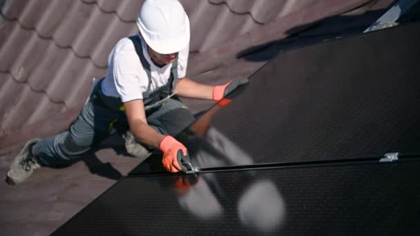 工人在房顶上建造光伏太阳能电池板系统 戴手套的人工工程师在室外用六角钥匙安装太阳能组件 替代和可再生能源生产概念 — 图库视频影像