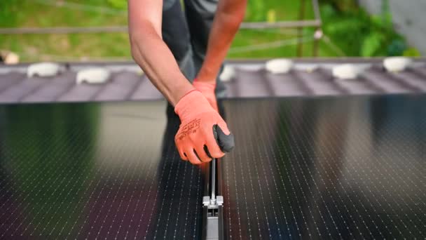 工人在房顶上建造光伏太阳能电池板系统 在室外用六角钥匙安装太阳能组件的手套中的人类工程师的近视 可再生能源生产概念 — 图库视频影像