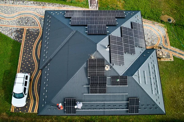 Installateure Bauen Photovoltaik Solarmodulstation Auf Hausdach Männer Elektriker Helmen Installieren lizenzfreie Stockbilder