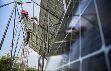 Metal kirişlere güneş panelleri kuran işçiler. Takım çalışması. Yenilenebilir ve ekolojik enerji kavramı. Modern teknoloji ve yenilik. Çevre fikri güvenli. Alt manzara. Güneşli bir gün