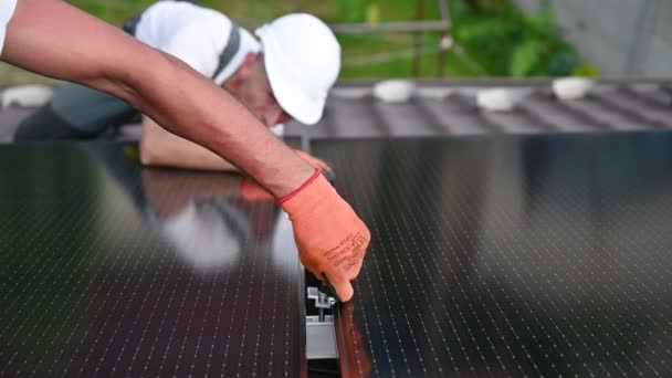 在房顶上建造太阳能电池板系统的工人 两名戴手套的男子在室外安装光电太阳能组件 绿色和可再生能源发电概念 — 图库视频影像