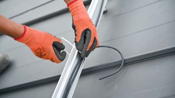 在房顶安装太阳能电池板系统的工人 专人绑扎电缆的近景 替代能源和可再生能源的概念 — 图库视频影像