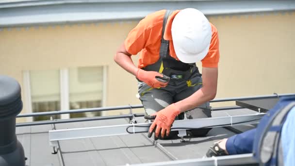 太陽光発電による発電のために家の屋上に太陽電池パネルシステムを設置する労働者 特別なネクタイでケーブルを固定する電気技師を閉じます 再生可能エネルギーの概念 — ストック動画