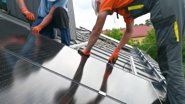 在房顶上建造光伏太阳能电池板系统的工人 男性技术人员在室外用六角钥匙安装太阳能组件 替代和可再生能源生产概念 — 图库视频影像