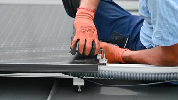 工人在房顶上建造光伏太阳能电池板系统 在室外用六角钥匙安装太阳能组件的手套中的人类工程师的近视 可再生能源生产概念 — 图库视频影像