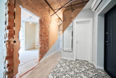 Kapıları ve beyaz duvarları olan yenilenmiş bir daireyle eski dairenin karşılaştırılması. Restorasyondan önce ve sonra dairenin fotoğraf kolajı. Ev yenileme konsepti.