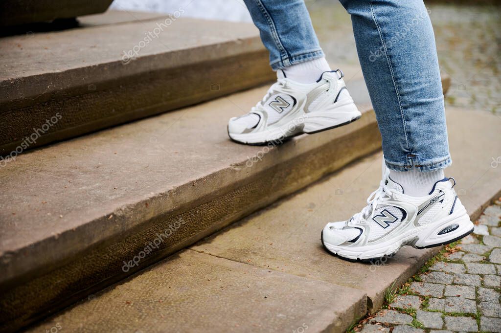 Lviv, Ukraine - May 9, 2023: active girl climbing the stairs. Cropped shot of girl in New Balance 530 sneakers.