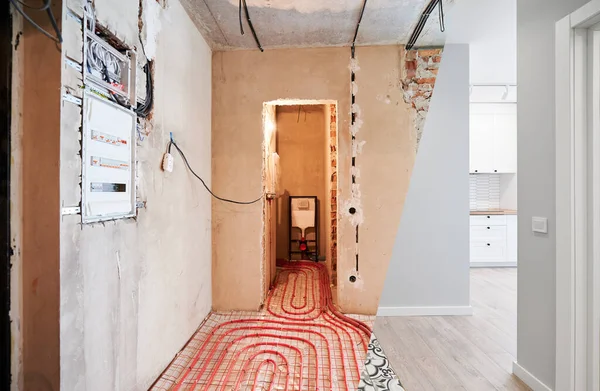 Comparison of old flat with underfloor heating pipes and new renovated apartment with modern interior design. Bathroom, hallway with heated floor before and after renovation.