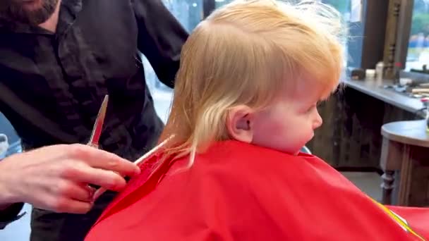 Чоловік Перукар Ріже Маленьких Хлопчиків Волосся Допомогою Гребінця Ножиць Дитина — стокове відео